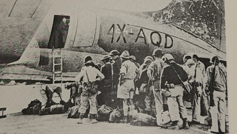 Palmach troops crowd the door of a C-46 transport 4X-AQD on a desert airstrip